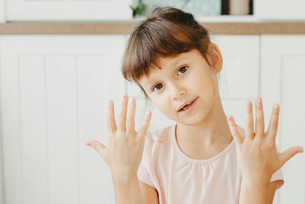 Six year preschooler girl show nails with nail polish